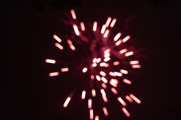 Burst of red blurred out of focus fireworks at night - vibrant streaks and sparks - smoke clouds - celebration, new years day, fourth of july, canada day. Taken in Toronto, Canada.