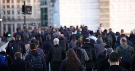 Slow motion shallow focus view of a large crowd of commuters going to work in the City during morning time, London, England - Powered by Adobe
