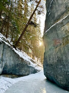 Sun appearing in the Grotto Canyon on an icy floor in Canmore, Alberta