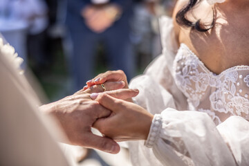 Wedding rings exchange with bride putting a ring on her future husband's finger