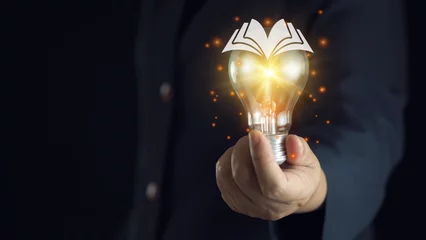 Fotobehang light bulb glowing on book, idea of ​​inspiration from reading, innovation idea concept, Self learning or education knowledge and business studying concept. © Bird Photographer TH