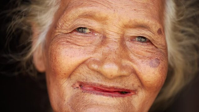 authentic portrait of joyful old asian woman in rural asia, grey hair, facial expression