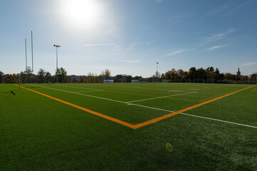 Brand new football pitch with yellow lines at sunset
