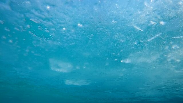 Panorama of thin ice on the surface of river on turquoise sky background, Underwater view, Slow motion, Ice diving. Ice drifts along the river. Frozen water surface
