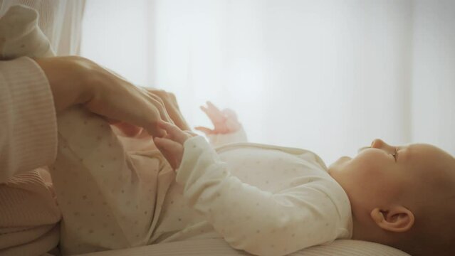 Developmental exercises and massage care for the baby. Mom pays special attention to exercises for arms and legs, promoting the physical development and coordination of the baby&rsquo;s movements