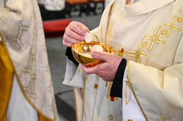 Catholic priest gives holy communion to believer in cathedral. Midnight Holy Mass on Christmas Eve....