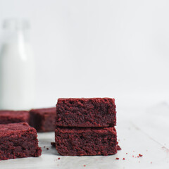 Thick red velvet brownies on a white tray, red velvet fudge brownies on a white background,...