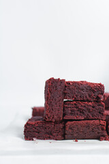 Thick red velvet brownies on a white tray, red velvet fudge brownies on a white background