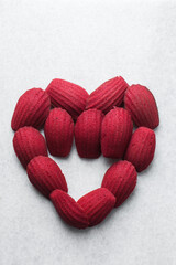 Fototapeta premium Red velvet madeleines on a marble tray shaped like a heart, red madeleines cake or cookies for valentines