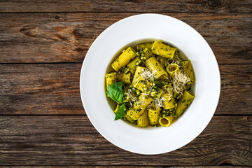 Pasta with basil pesto sauce on wooden table
