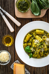 Pasta with basil pesto sauce on wooden table
