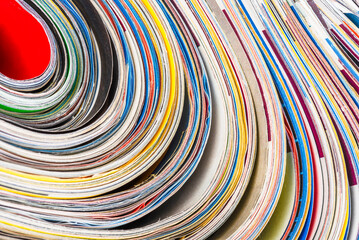 Colorful background stacked and rolled magazines