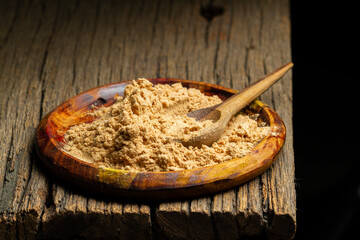 maca powder on rustic wood, close-up image
