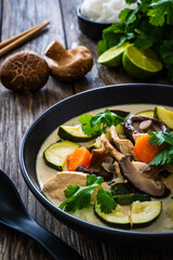 Tom Kha Gai soup - Thai soup with chicken breast nuggets and noodles on wooden table