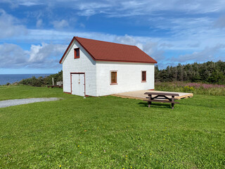 White clapboard shed with red roof and trim at the Lobster Cove Head Lighthouse at Gros Morne...