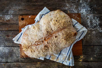 Loaf of homemade, fresh baked cottage bread on wooden table
