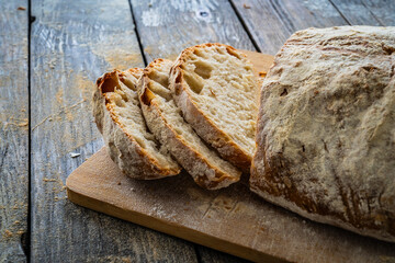 Loaf of homemade, fresh baked cottage bread on wooden table
