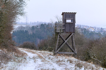 Wooden lookout tower for hunting in the woods and on meadow
