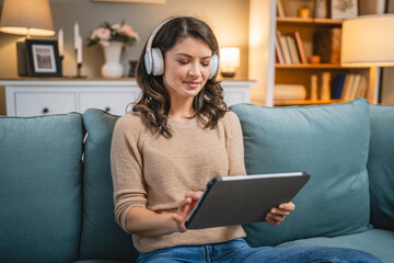 woman sit on the sofa bed watch movie video online use digital tablet