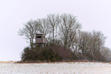 Wooden lookout tower for hunting in the woods and on meadow

