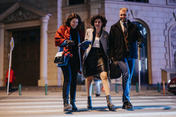 Stylish businesspeople enjoying a night out in the city. Friends laugh and chat as they cross the...