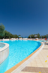 Swimming pool on sunny day by sea