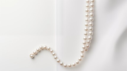 A single elegant pearl necklace draped gracefully on a clean pure spotless white surface