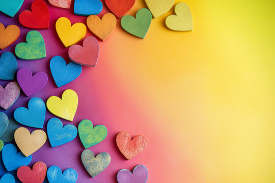 Colorful wooden hearts on a gradient background.