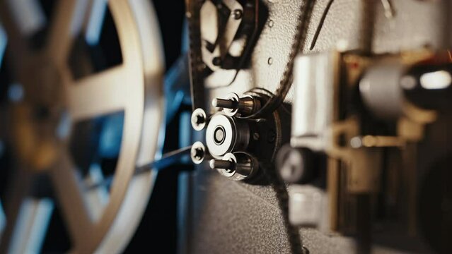 Retro projector playing motion picture. dark room. Timeless flicker of old films