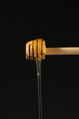 Yellow liquid honey dripping from the honey spoon