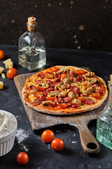 Homemade pizza with mushrooms, sausage, tomatoes and cheese. Simple country food.