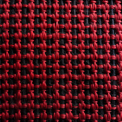Fototapeta premium Close-up of a woven red fabric showing detailed texture and interlaced threads