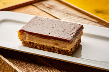 Chocolate Caramel Slice bar served in dish isolated on wooden table top view of arabic sweet dessert