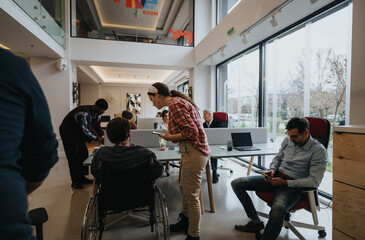 Diverse team collaborating in modern office space with wheelchair inclusion.