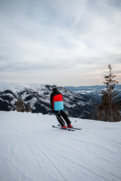 skier on a ski slope during a sunset with colorful sky