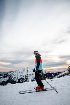 skier on a ski slope during a sunset with colorful sky