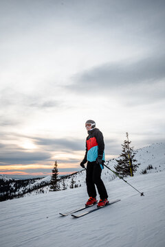 skier on a ski slope during a sunset with colorful sky