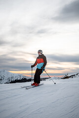 skier on a ski slope during a sunset with colorful sky