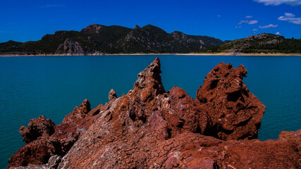 Red stones, blue sky, green water