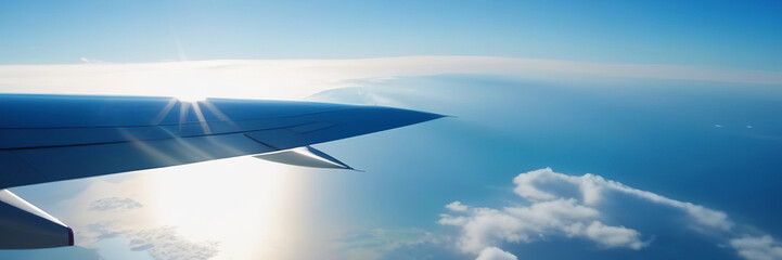 Obraz premium Flying above the sea of clouds. Features bright blue sky and white clouds. Slight curvature of the Earth at the horizon. Travel and vacation concept. Copy space banner
