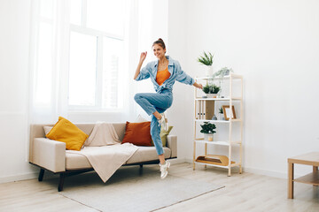 Joyful Woman Jumping and Dancing in a Playful Indoor Concept: Relaxation and Carefree Happiness