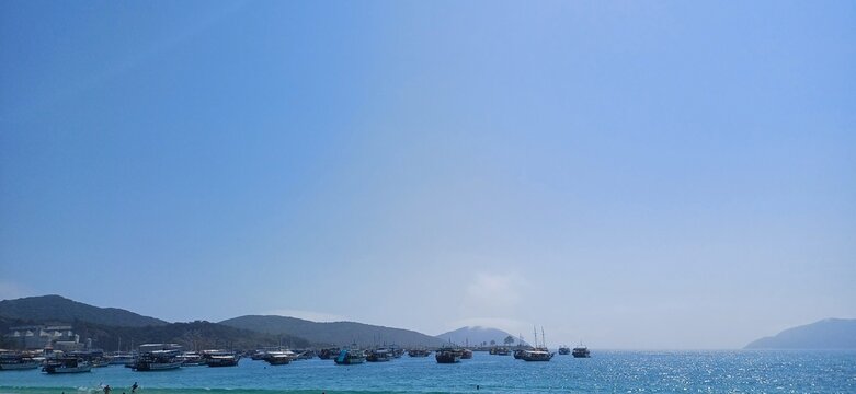 Sea, boats, blue sky and mountains in the background