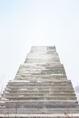 Stairs to nowhere. Empty unfinished bridge. Outdoor staircase without end. Stairway to heaven. Bridge under construction. Stairs against cloudy sky. Steps to heaven. Lifestyle background. Minimal back