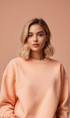 A girl in a sweatshirt or jumper in the color of peach fuzz. Isolated on a pink background. Concept of style, fashion and textiles, trends 2024. copy space