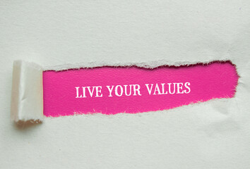 Live your values lettering on torn paper with pink background. Conceptual symbol. Copy space.