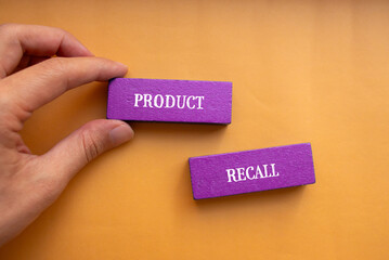 Product recall lettering on wooden blocks with orange background. Conceptual business symbol. Top...