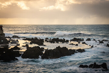sunset, waves crashing on natural lava swimming pools of porto moniz, madeira, atlantic ocean, portugal, europe, storm, waves, lava