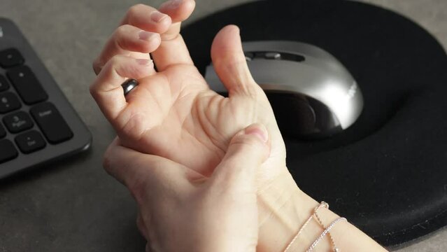 Gros plan d'une femme avec une douleur &agrave; la main due &agrave; l'utilisation d'un ordinateur.