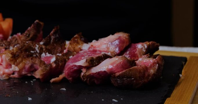 salting a piece of meat cooked on the grill