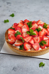 Strawberry tart with butter cream on a white wooden table. French delicious dessert. Fresh and beautiful tart.